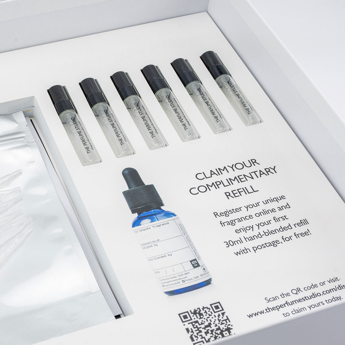 Set of perfume bottles for trial scents before chosing a favourite with a promotional card for a complimentary refill offer.