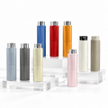A set of eight twist-up atomisers in various colors, including blue, red, orange, light blue, gray, cream, gold, pink, and taupe, arranged on clear acrylic blocks against a white background - designed to be refilled with bespoke fragrance.
