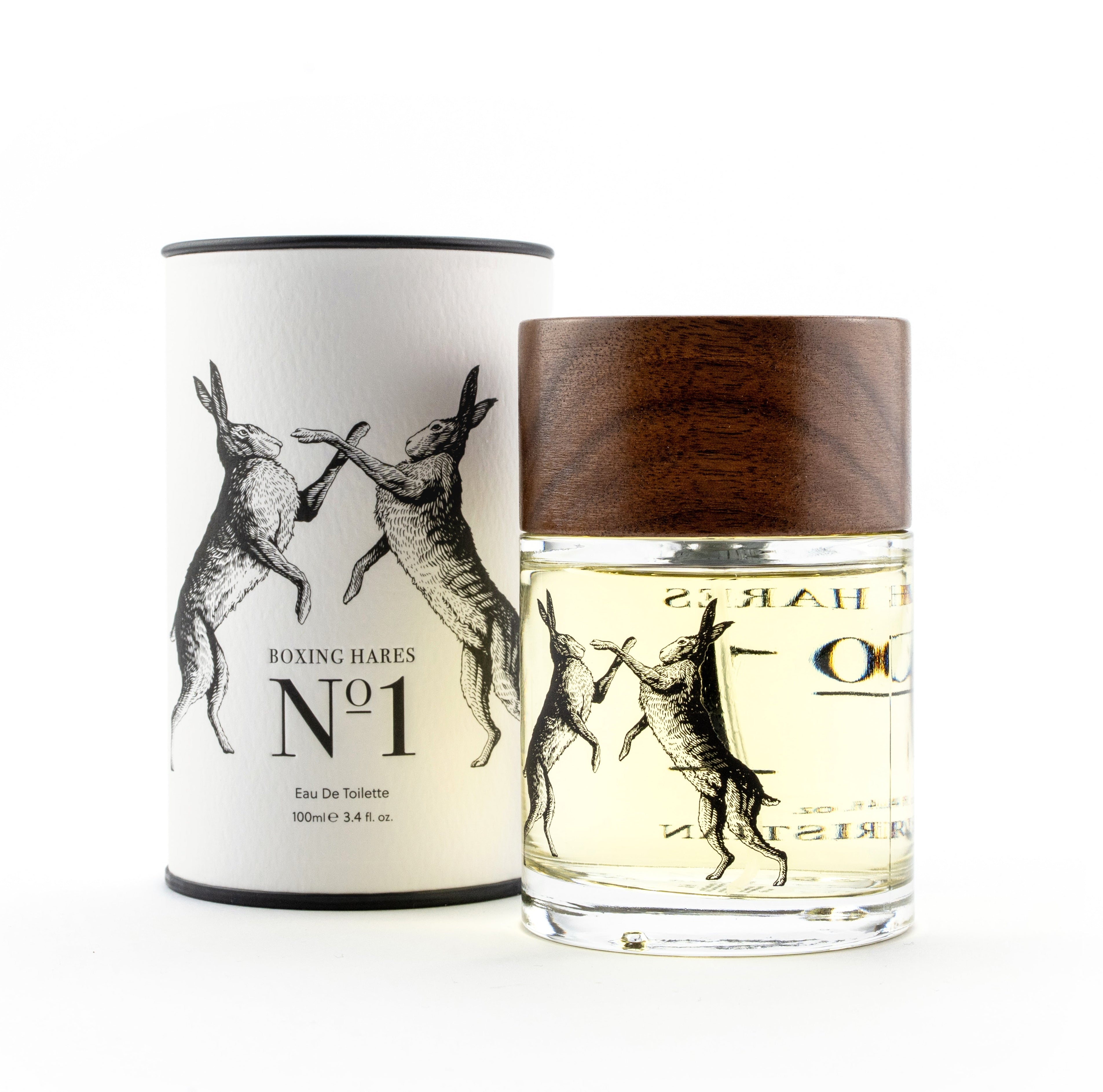 A bottle of Boxing Hares No. 1 Eau De Toilette perfume with a dark wood cap, shown next to its white cylindrical packaging box with black rabbit illustrations, on a white background.