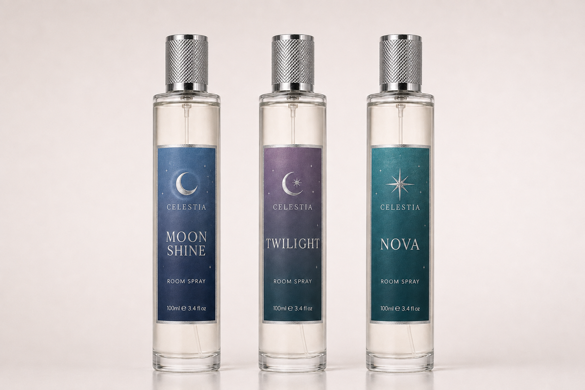 Three tall clear glass room spray bottles with silver caps from the brand Celestia, shown against a light beige background. The labels read Moon Shine, Twilight, and Nova.