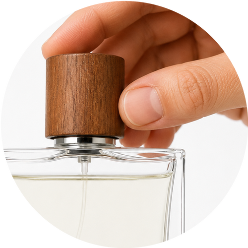A close-up of a hand unscrewing a cylindrical wooden cap from a clear glass perfume bottle with a transparent liquid inside, set against a white background with a circular frame.