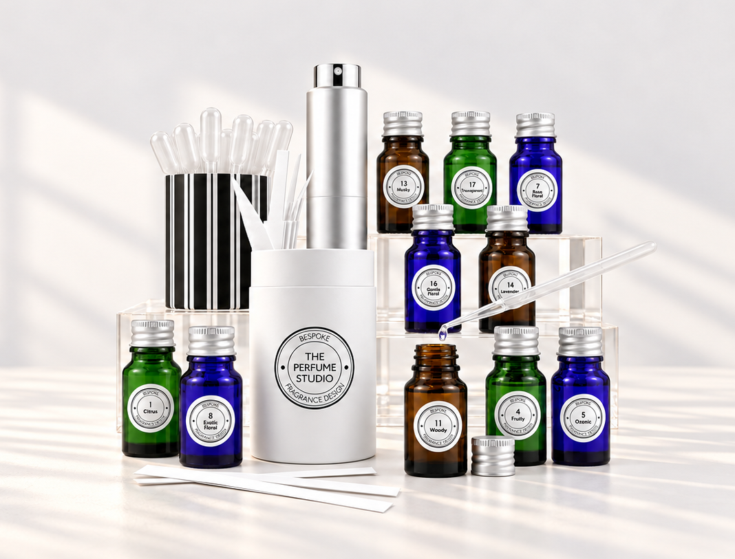 A perfume design collection kit. Fragrance blend bottles arranged on a white table with soft window shadows.
